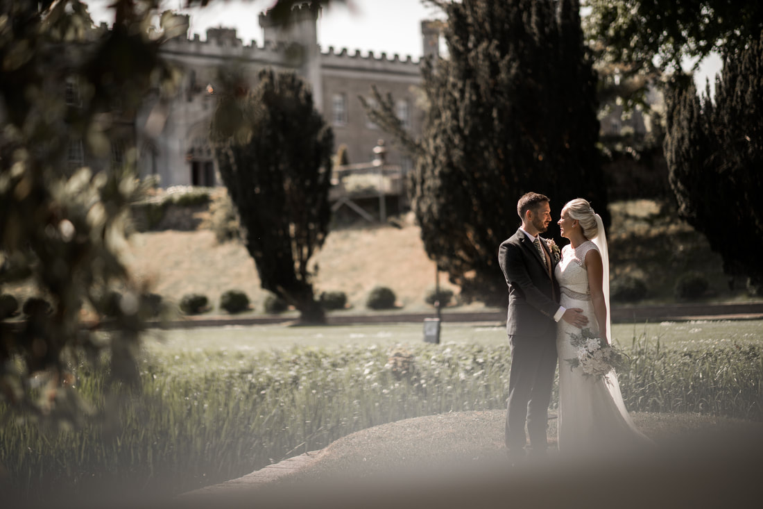 Bride and groom in a sunlight at a castle Bellingham, photo by Mario Vaitkus
