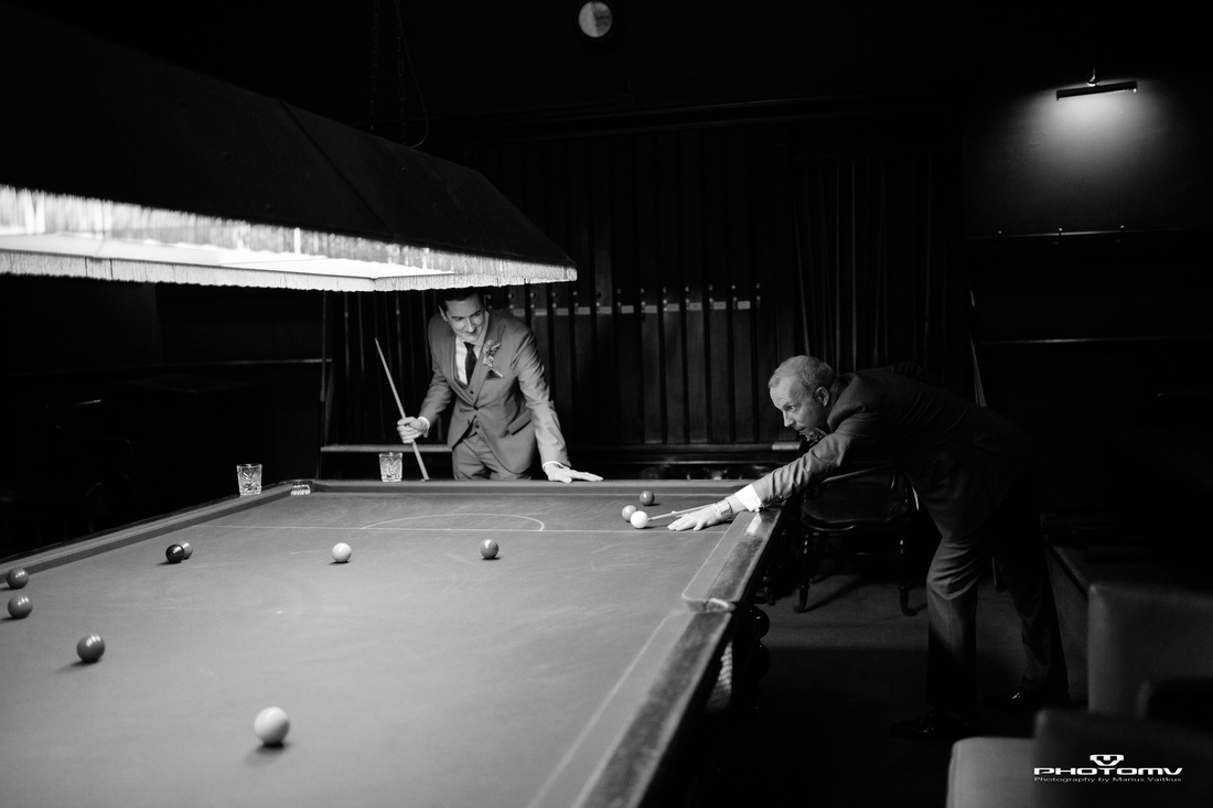 Gay couple play pool at a wedding. Gay wedding photography by Mario Vaitkus